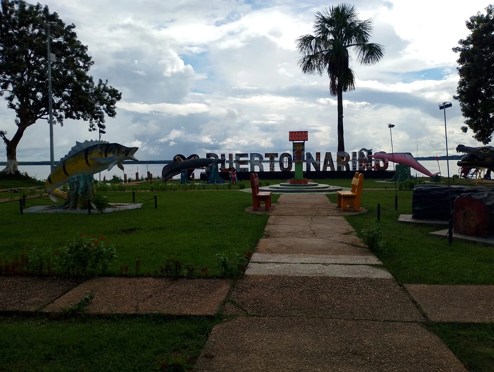 Letras de Puerto Nariño en un espacio verde con palmeras